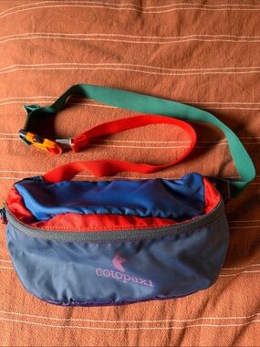 cotopaxi navy blue belt bag with red and teal straps
